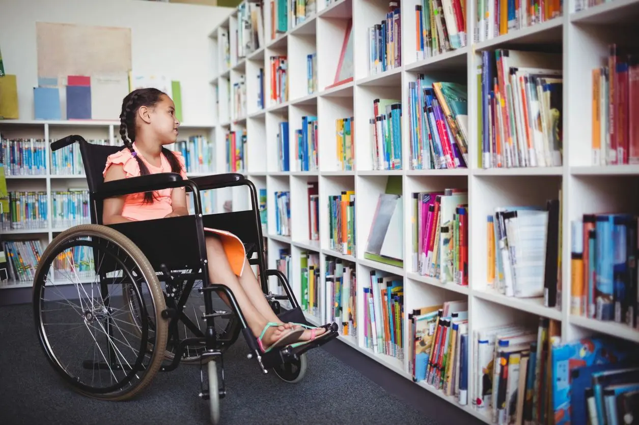 A person in a wheelchair is sitting on the floor