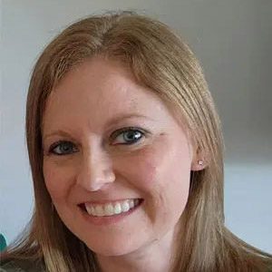 A woman with long hair and blue eyes smiling.