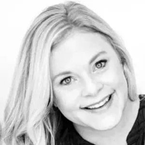 A black and white photo of a woman smiling.